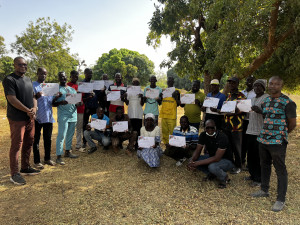 Gruppenfoto mit Mike Dera von der ÖJAB links, den Imker:innen mit dem Ausbildungszertifikat und Dr. Aristide Kaboré dahinter rechts.