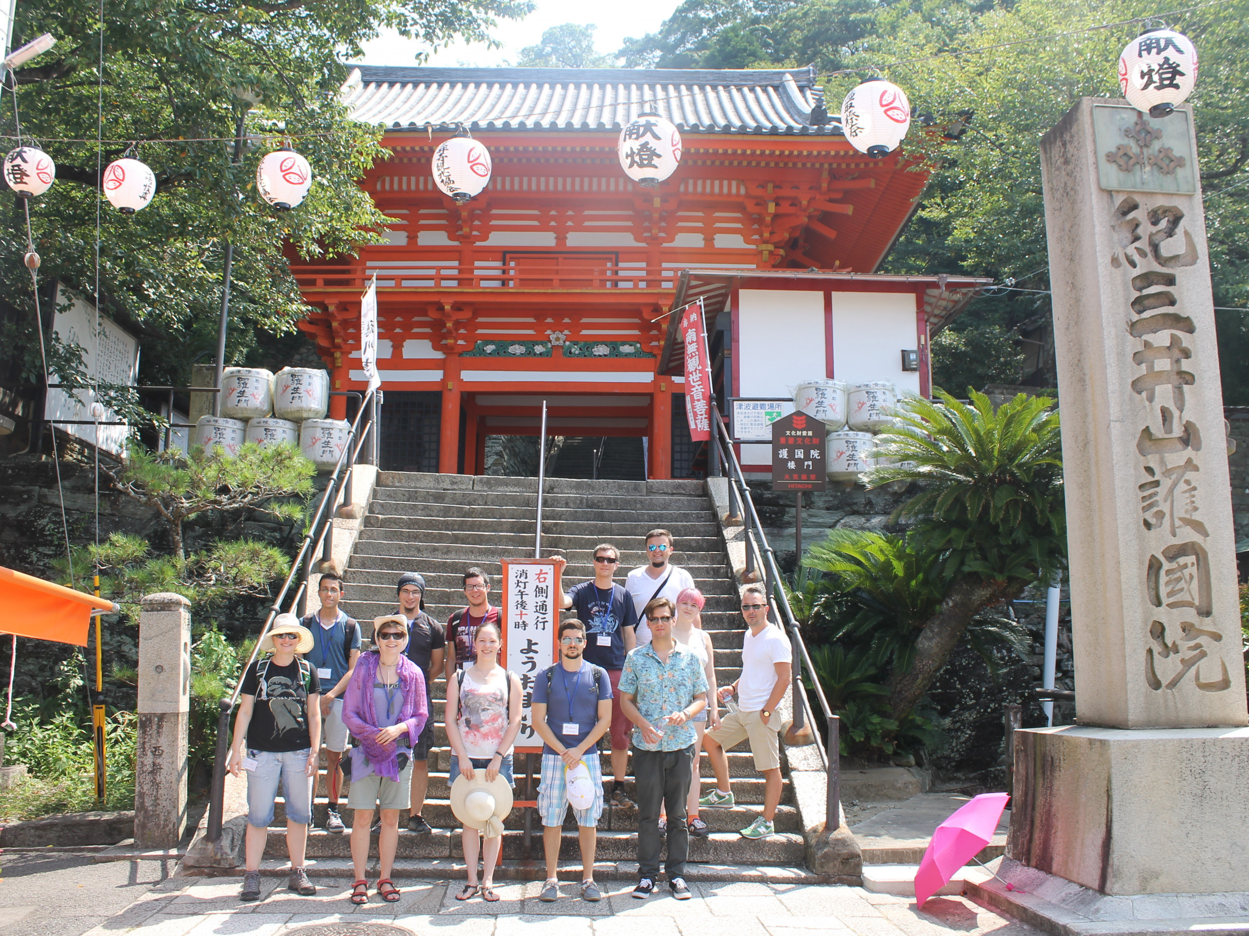 Teenagers from Austria in Japan. The group stands in front of a Japanese temple entrance.