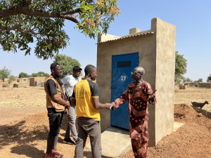 Von links nach rechts, M. Tidiani Ouedraogo (GRAD-A), M. Mike Dera (ÖJAB), M. Amos Zoundi (Laafi Zaka) und M. Ouedraogo (Begünstigter) bei der Diskussion über die Qualität der Latrine und die Auswirkungen auf die Hygiene in seiner Konzession.